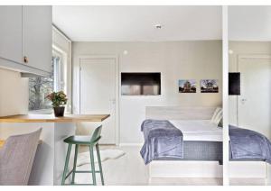 a bedroom with a bed and a table and a kitchen at Avanti Apartment Hotel in Stockholm