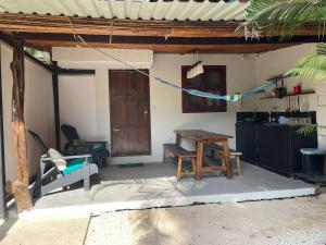 een patio met een tafel en een stoel in een huis bij Beach Cabinas in Santa Teresa Beach