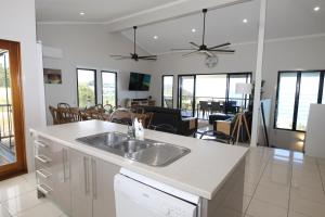 a kitchen with a sink and a living room at Nirvana in Tangalooma