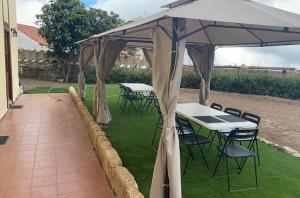 a patio with tables and chairs under a canopy at La Casa Inglesa Vilaflor in Vilaflor