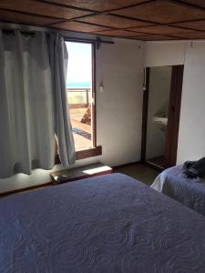 a bedroom with a bed and a large window at Carmela Cabo Polonio in Cabo Polonio