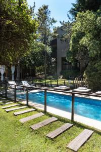 a swimming pool with lounge chairs next to it at Plenilunio Mar de las Pampas in Mar de las Pampas