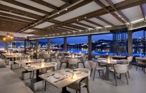 a restaurant with tables and chairs with a view at Aeonic Suites and Spa in Mikonos