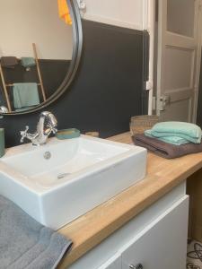 een badkamer met een witte wastafel en een spiegel bij Gîte en RDC 72m2 - 2 chbres - Box Vélos - Parking in Bourg-Saint-Andéol