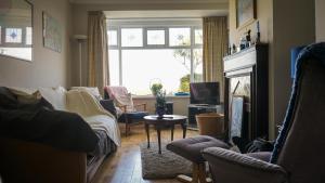 a living room with a couch and a fireplace at Little Oak Seafront House Donaghadee w/ Seaviews in Donaghadee