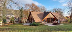 a house with a brown roof in a field at La Canopée Alsacienne - Magnifique maison à Ribeauvillé in Ribeauvillé