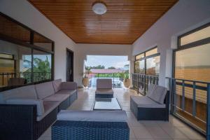 een woonkamer met een bank en stoelen op een balkon bij The Cabyn in Accra