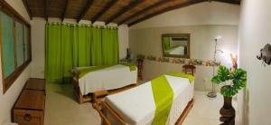 a bedroom with two beds and a green curtain at Hotel La Floresta Salento in Salento +174 photos