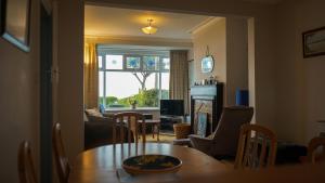 a living room with a dining room table and a window at Little Oak Seafront House Donaghadee w/ Seaviews in Donaghadee
