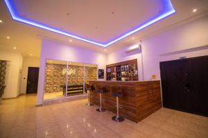 a bar with stools in a room with purple lighting at The Cabyn in Accra