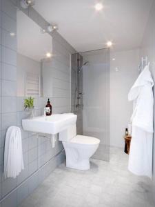 a white bathroom with a sink and a toilet at Avanti Apartment Hotel in Stockholm