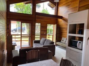 a living room with a couch and a tv at Chale Morada da Serra in Canela