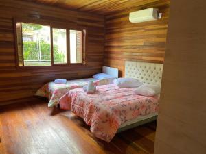 a bedroom with two beds and two windows at Chale Morada da Serra in Canela