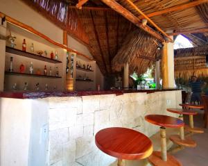 a bar with stools and a counter in a restaurant at Hotel Circulo Bacalar in Bacalar