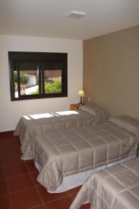 three beds in a room with a window at Departamentos Ibazeta in Salta