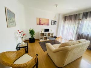 uma sala de estar com um sofá e cadeiras em Apartamento Coselhas Coimbra em Coimbra