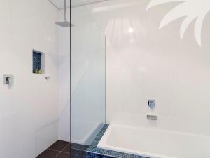a bathroom with a tub and a glass shower at Beach Break in Blueys Beach