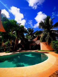 una piscina en un patio con palmeras en Hotel Circulo Bacalar en Bacalar