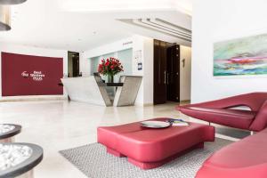 ボゴタにあるBest Western Plus 93 Park Hotelのリビングルーム(赤い家具、テーブル付)