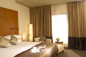 a hotel room with a large bed and a large window at Radisson blu Dhaka Water Garden in Dhaka