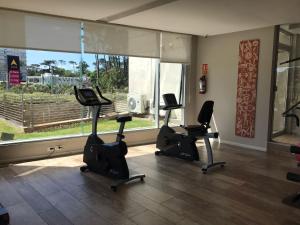 a gym with three cardio bikes and a large window at Gala Vista in Punta del Este