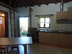 cocina con fregadero y mesa en una habitación en Casa do Pastor, en Lousã