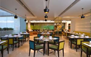 a dining room with tables and chairs and a restaurant at Country Inn & Suites By Radisson, Bengaluru Hebbal Road in Bangalore