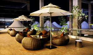 a restaurant with couches and tables and an umbrella at Radisson Blu Chattogram Bay View in Chittagong