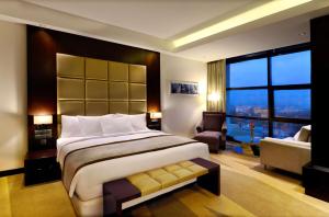 um quarto com uma cama grande e uma janela grande em Radisson Blu Chattogram Bay View em Chittagong