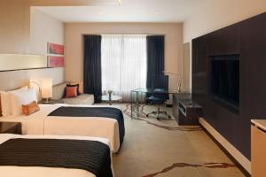 een hotelkamer met 2 bedden en een bureau bij Radisson Blu Hotel Amritsar in Amritsar