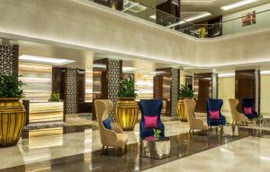 a lobby of a hotel with blue and gold chairs at Radisson Blu Hotel, Ajman in Ajman 