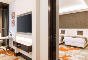 a hotel room with a television and a bed at Radisson Blu Hotel, Ajman in Ajman 