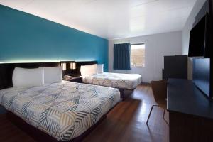 Habitación de hotel con 2 camas y pared azul en Motel 6-Merrillville, IN, en Merrillville