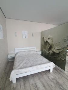 um quarto com uma cama com um quadro na parede em Яровиця. Центр em Lutsʼk
