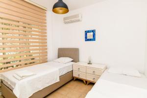 2 łóżka w pokoju z białymi ścianami w obiekcie Villa Leo Bodrum w mieście Yalıkavak