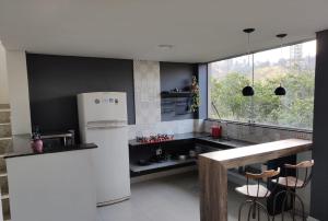 uma cozinha com um frigorífico branco e uma janela em Loft Espaço Vila da Serra em Nova Lima