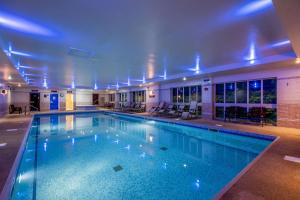 - une grande piscine avec des lumières bleues dans un bâtiment dans l'établissement The Barn Hotel & Spa, Sure Hotel Collection by Best Western, à Grantham