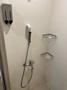 a shower with a shower head and shelves in a bathroom at 幸福客棧 in Ho-mei