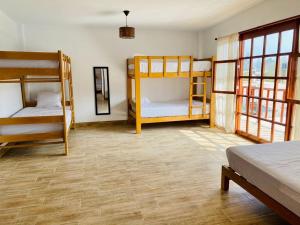 a room with three bunk beds and a room with at Casa La Parcela en Cieneguilla in Cieneguilla +22 photos