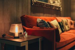 Eine orangefarbene Couch mit Kissen auf einem Tisch mit einer Lampe in der Unterkunft CHECK inn SELECT Chiayi RenAi in Chiayi + 238 Fotos
