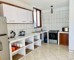 a kitchen with white cabinets and a stove top oven at Casa La Parcela en Cieneguilla in Cieneguilla