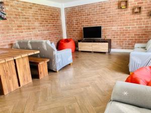 a living room with a brick wall and a television at Casa La Parcela en Cieneguilla in Cieneguilla