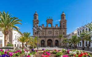 an old church with palm trees and flowers at Alcaravaneras Home in Las Palmas de Gran Canaria