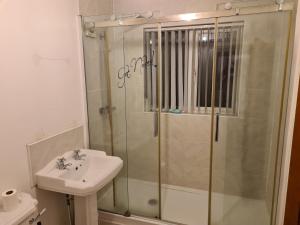 a bathroom with a shower and a sink at L & J ESCAPES- 4 BEDROOMs SUITABLE FOR CONTRACTORS AND FAMILIES- LARGE PRIVATE PARKING-10 MINUTES TO M6 JUNCTION 9 in Coseley