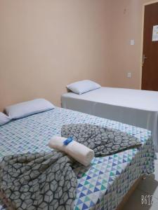 two beds sitting next to each other in a room at POUSADA ROTA DAS ÁGUAS in São Félix do Tocantins