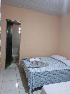a bedroom with two beds and a bathroom with a toilet at POUSADA ROTA DAS ÁGUAS in São Félix do Tocantins