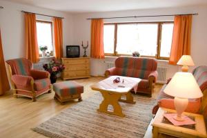 ein Wohnzimmer mit einem Sofa, Stühlen und einem Tisch in der Unterkunft Ferienwohnungen am Westernberg in Ruhpolding