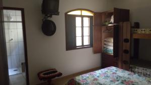 um quarto com uma cama e uma janela e um quarto com um lado lateral da cama em Casa 200m da praia 3 dorm. p/ 12 pessoas em Peruíbe