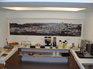 a kitchen with a counter with food on it at Hotel Botanico de Coimbra in Coimbra