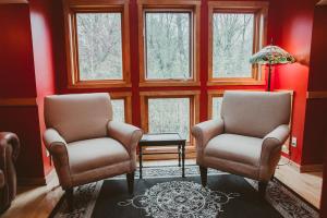 2 stoelen en een tafel in een kamer met ramen bij Garden Grove Inn Bed and Breakfast in Union Pier